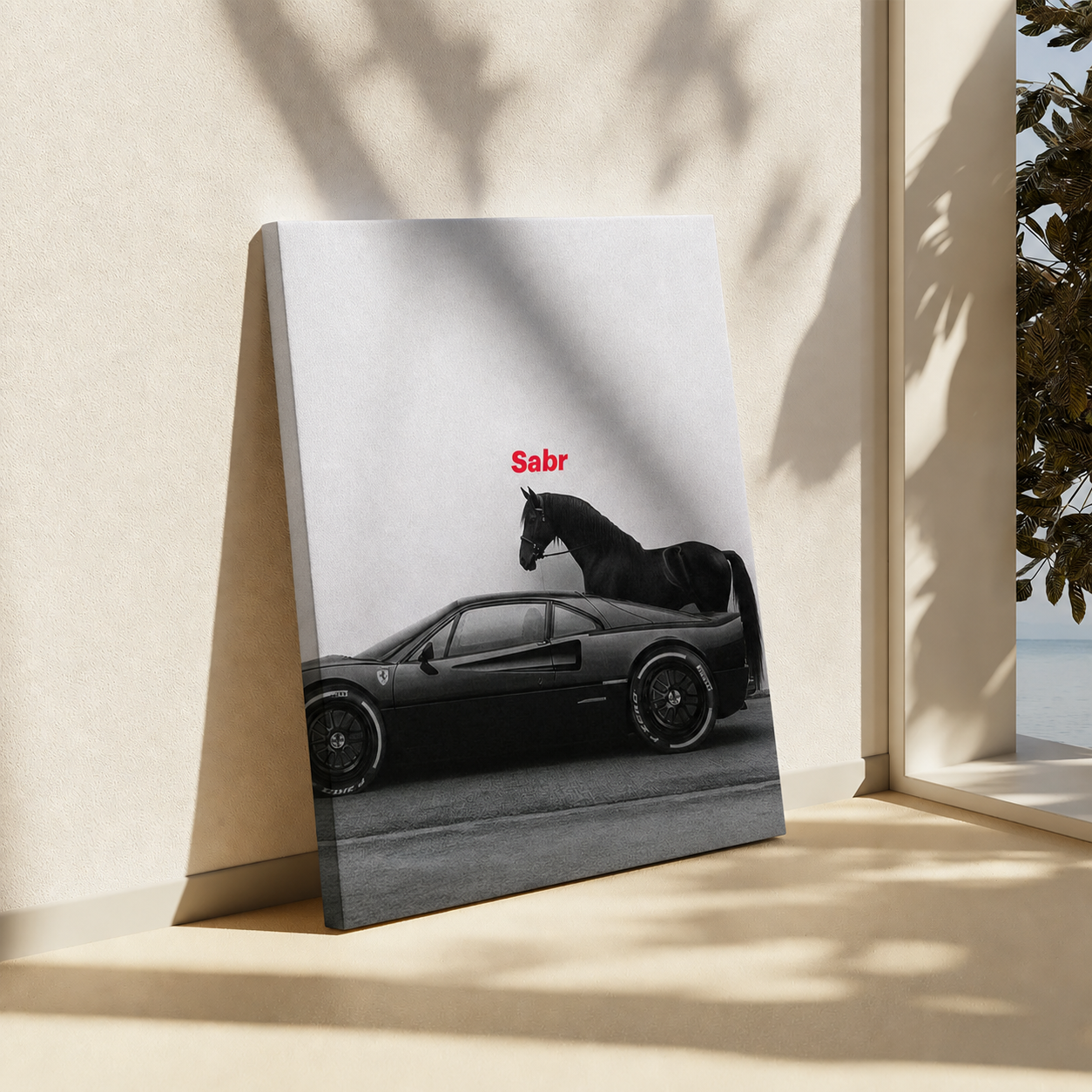 A vertical canvas art print leaning against a beige wall in a sunlit room. The print shows a black sports car with a black horse on a light gray background, with the word 'Sabr' in small red text above the car.