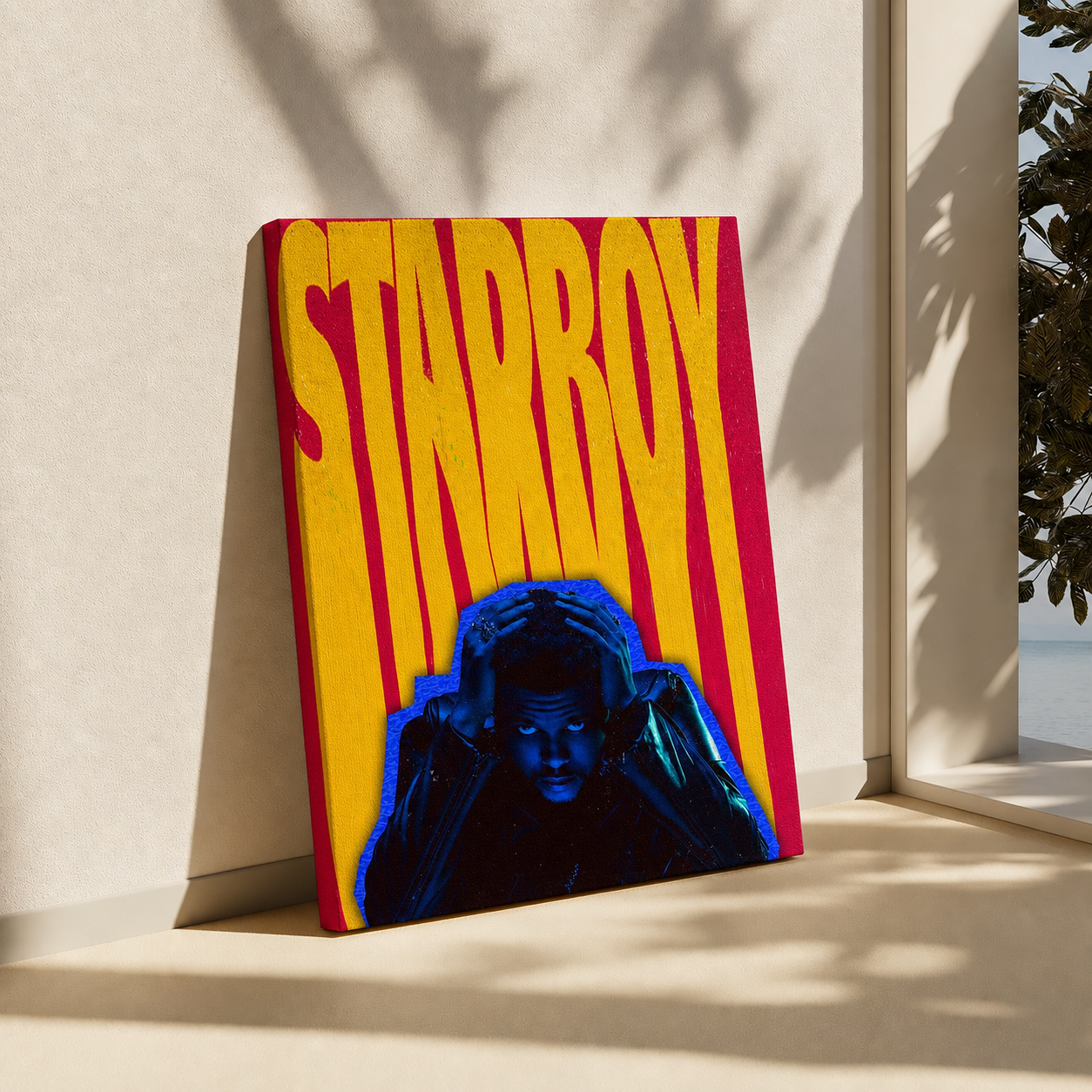 A square canvas art print leaning against a beige wall on a windowsill, featuring a vibrant graphic design with the word 'STARRY' in bold yellow letters over red and yellow stripes, and a blue-toned portrait at the bottom.