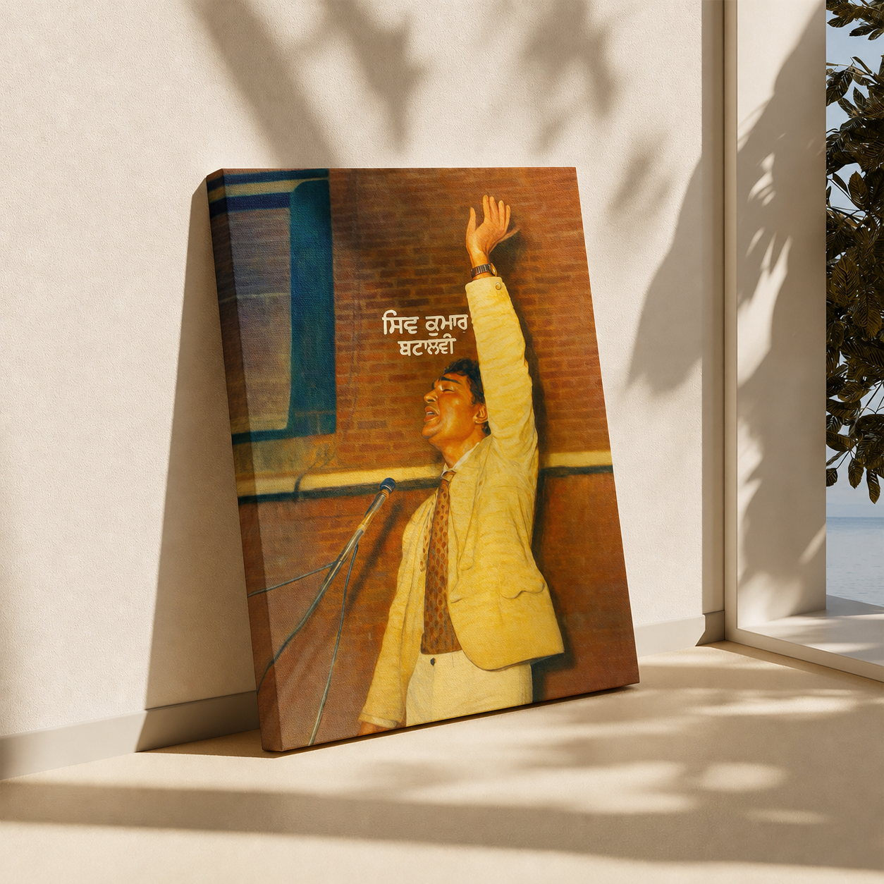 A rectangular wall art print or poster leaning against a light beige wall on a windowsill, showing a man in a yellow suit reaching upward against a brick wall. The print has white text in the upper center and is photographed in natural window light with leaf shadows cast across the scene.