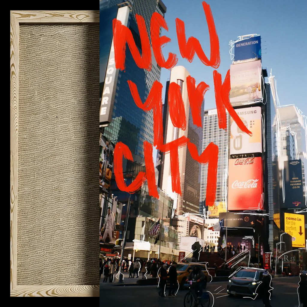 A square art print or canvas featuring a Times Square street scene with large red hand-painted text reading 'NEW YORK CITY' over a busy urban background. A narrow beige textured panel with wood grain borders appears along the left side of the composition.