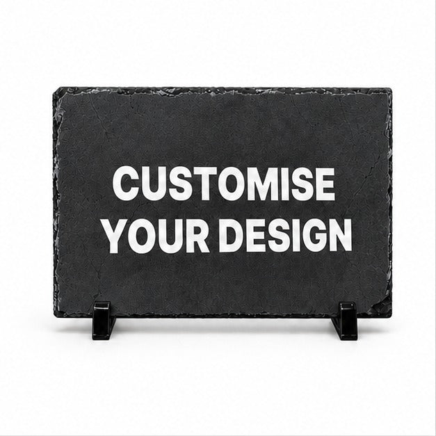 A rectangular black slate sign on small black display stands with the words 'CUSTOMISE YOUR DESIGN' in large white capital letters, shown on a plain white background.