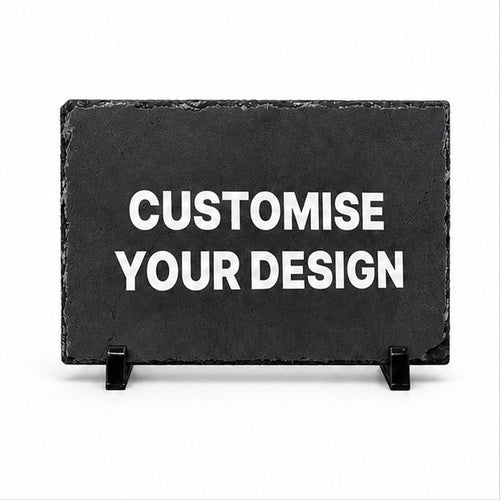 A rectangular black slate sign on small black display stands with the words 'CUSTOMISE YOUR DESIGN' in large white capital letters, shown on a plain white background.