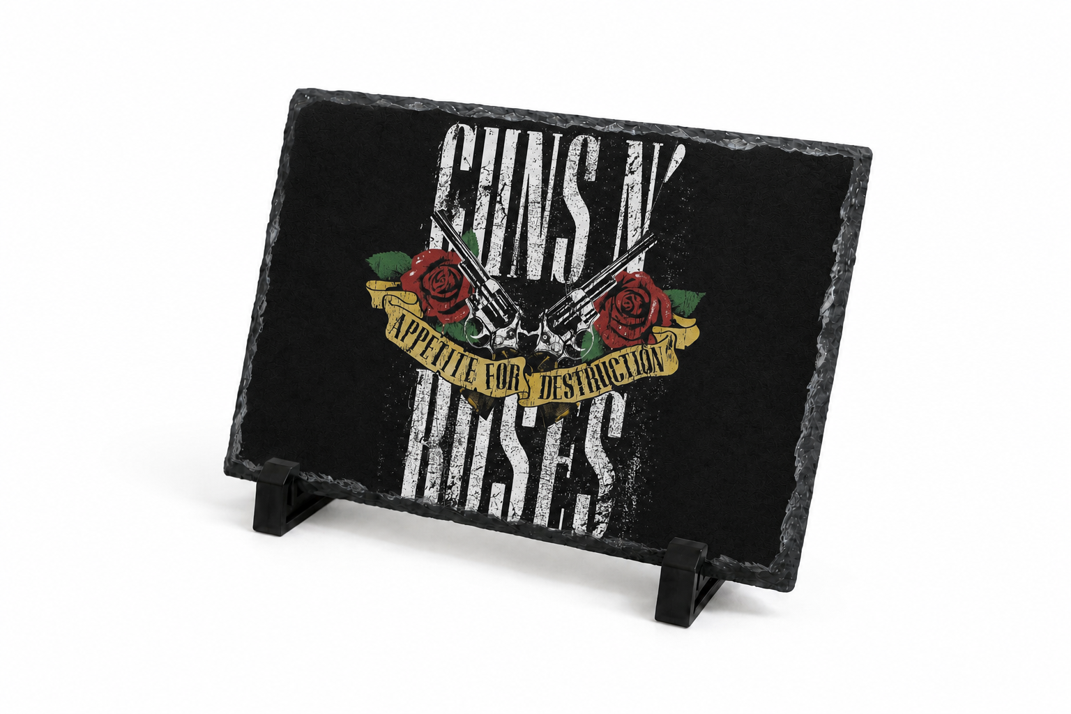 A rectangular black slate sign on a small black stand, featuring Guns N' Roses artwork with distressed white lettering, red roses, and a gold banner on a white background.