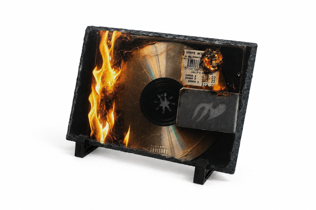 A black rectangular display stand holding a vinyl record with a fiery graphic print and a small black plaque featuring a stylized logo, photographed on a white background.