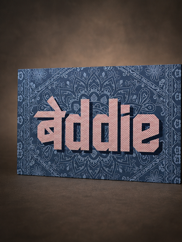 A rectangular canvas wall art print featuring the word 'Breddie' in large pinkish-beige block letters over a blue paisley bandana pattern, shown hanging against a dark brown wall.